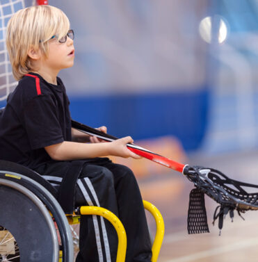 Young boy playing wheelchair Lacrosse